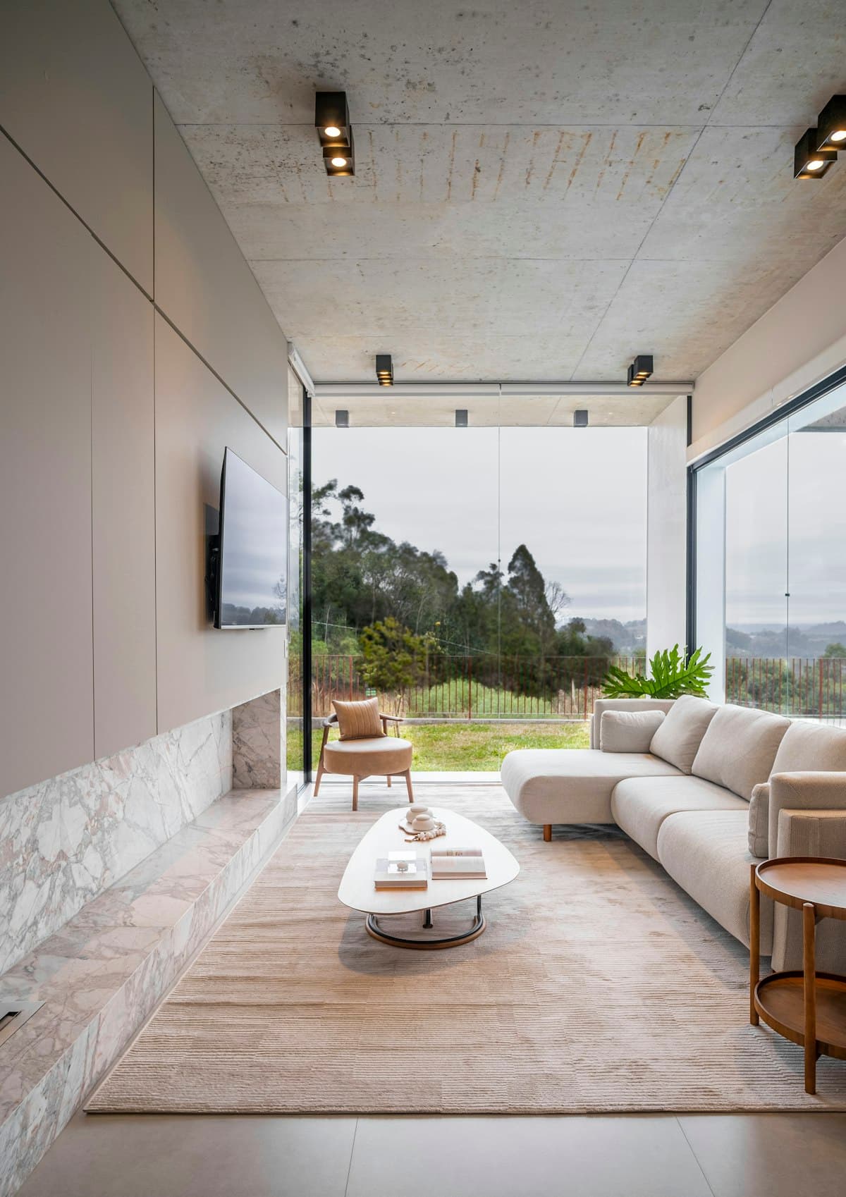 Modernt vardagsrum med stora fönster och ljusinsläpp