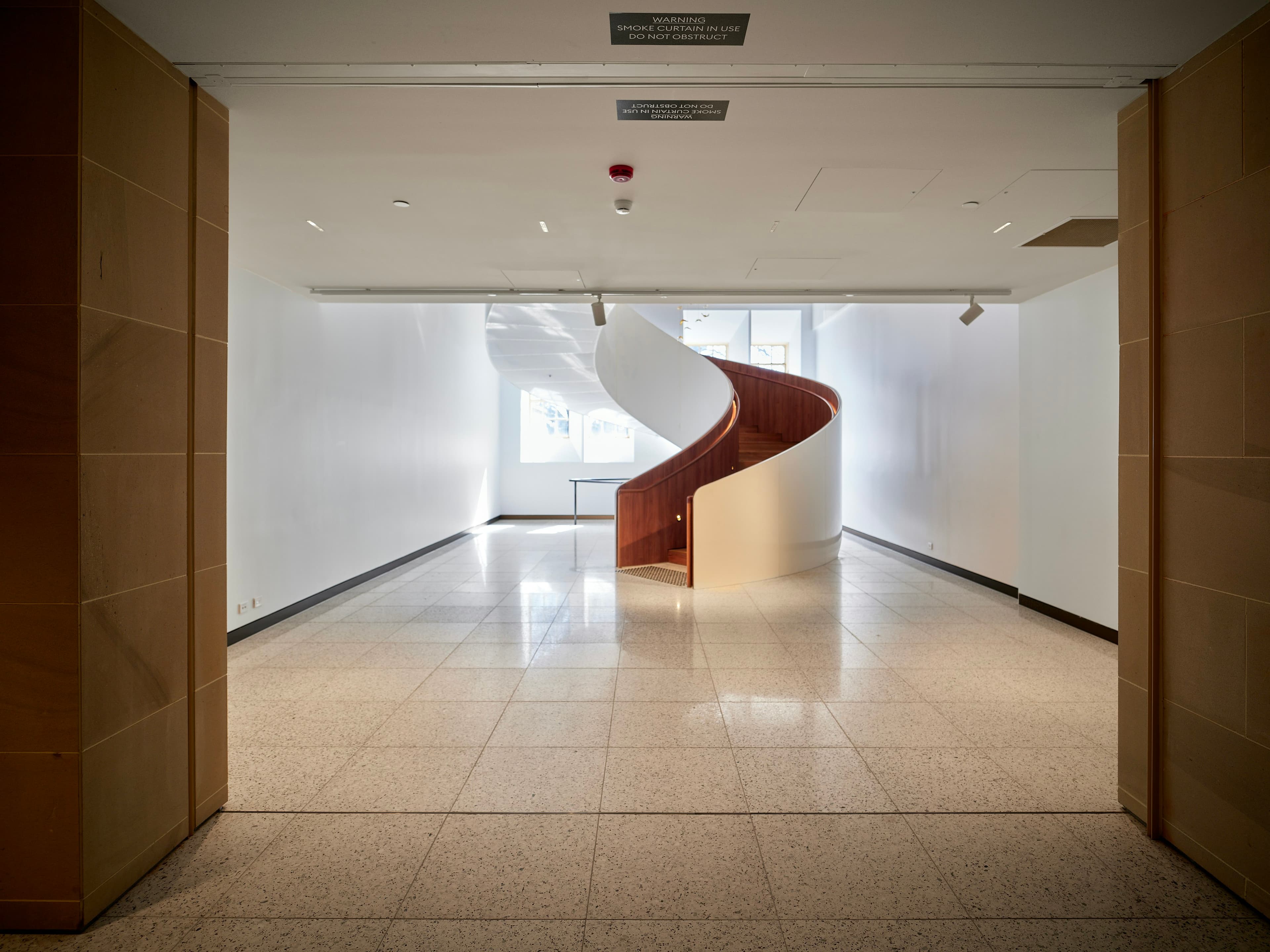 Modern spiraltrappa i ljust trapphus